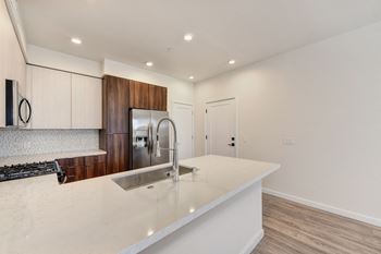 Kitchen with Quartz Counters, Hardwood Inspired Floor and Sink